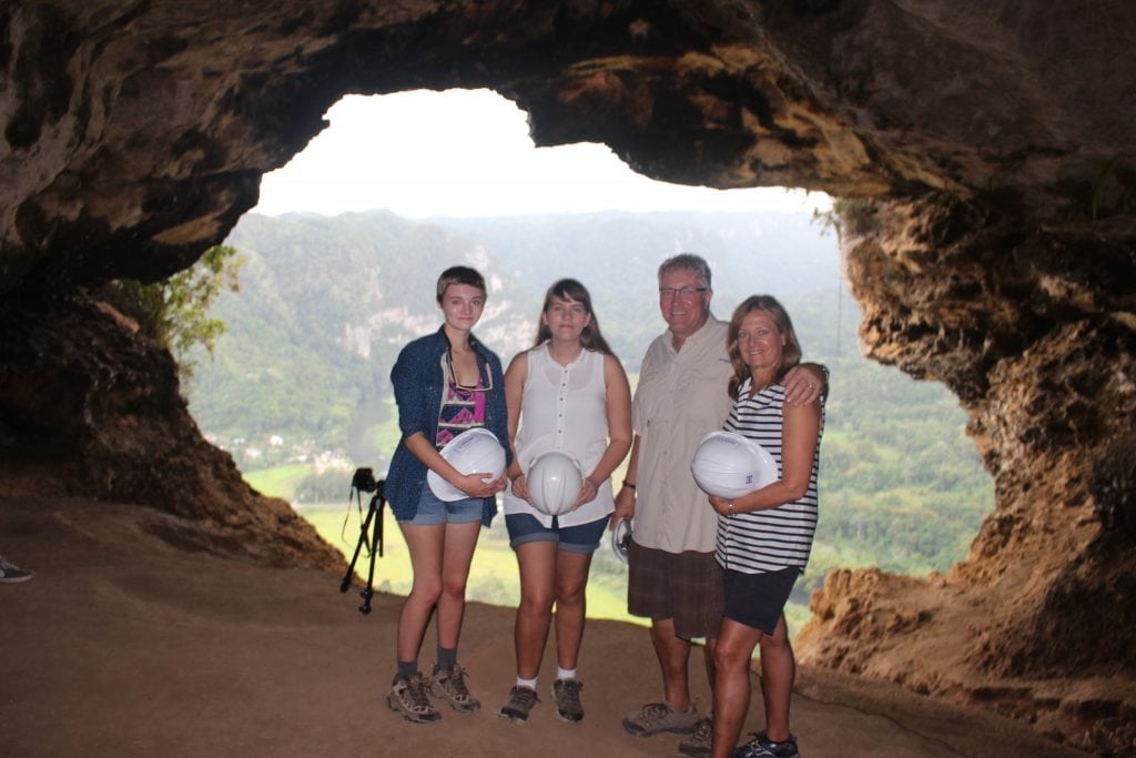 A family looking out from Cueva Ventana with a sweeping view of the valley